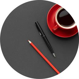 Arbeitszeit: Schreibtischunterlage mit Kaffeetasse und Stiften