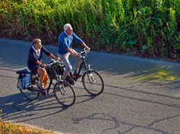 Two elderly people go on a bike ride